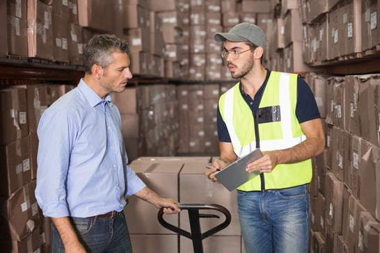 Warehouse manager talking with worker in a large warehouse.jpeg