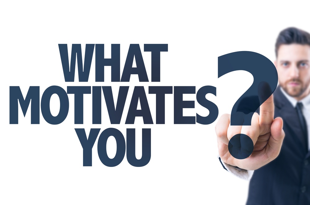 Business man pointing the text What Motivates You?.jpeg
